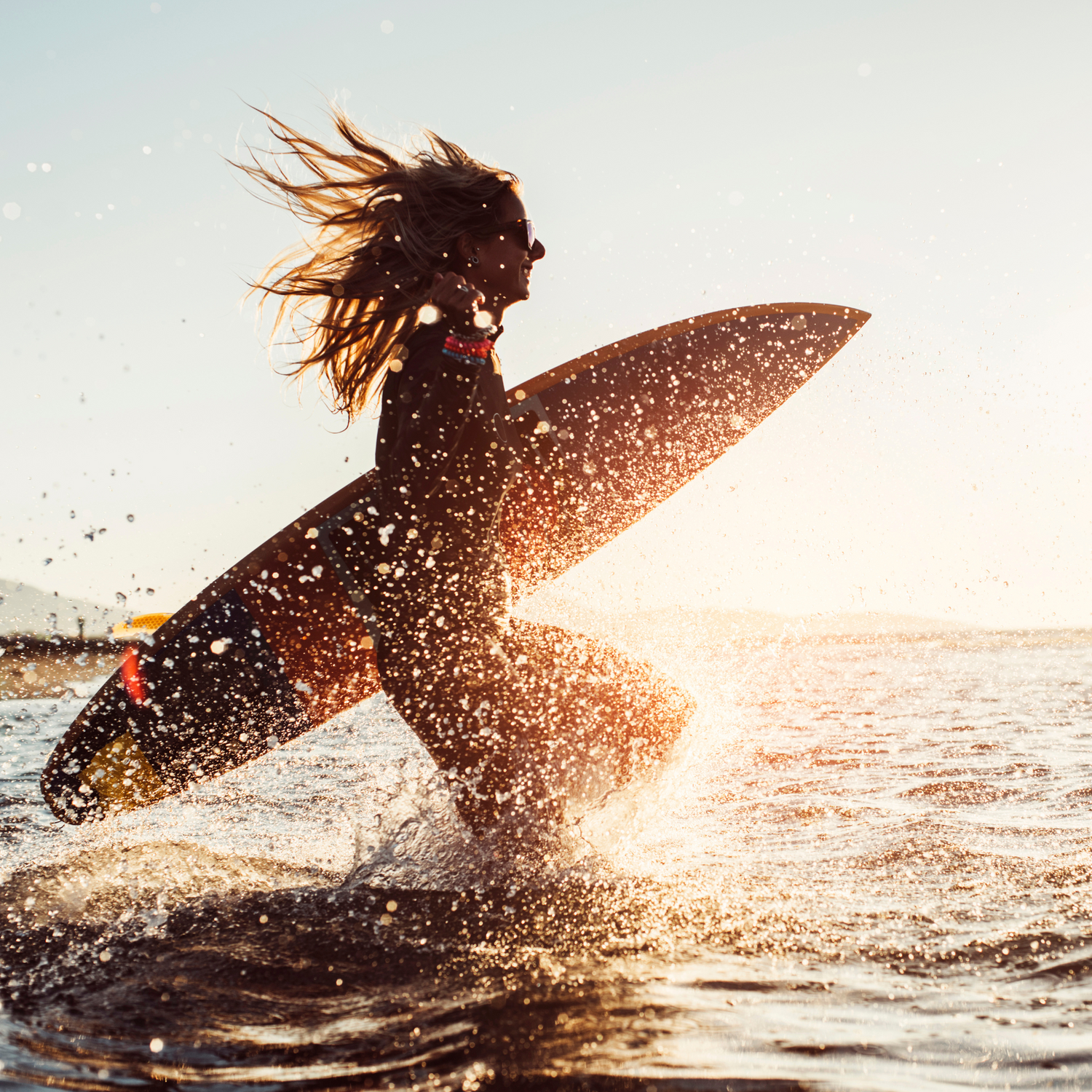 femme tenant une planche de surf